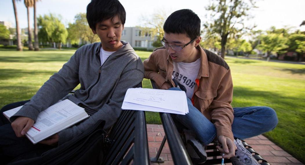 two students studying math together outside