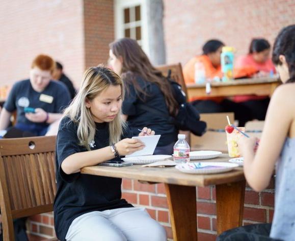 students at tables outside the duc